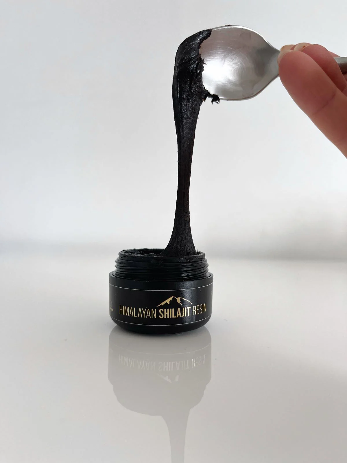 Shilajit resin being scooped with a spoon